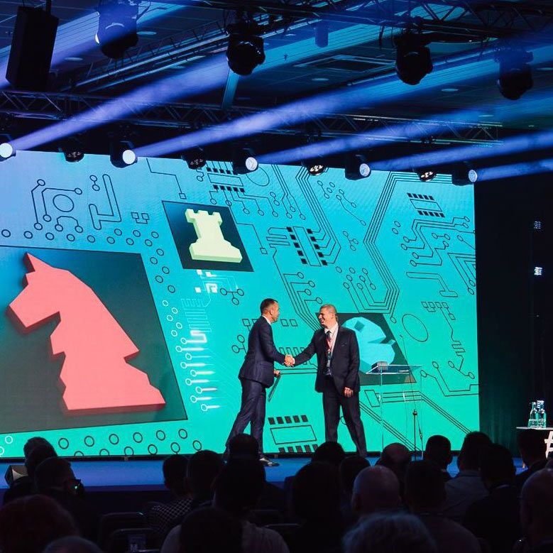 Ieturēta struktūra, iedvesmota **auditorija** — klātienē un tiešsaistē.